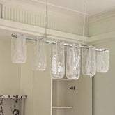 Linear pendant light with multiple clear glass tubes hanging from a metal bar