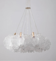 Modern chandelier with glass shades and metallic accents on a gray background