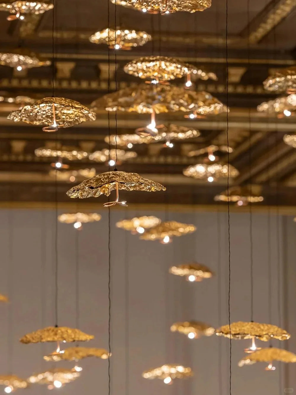 Gold chandelier hanging from a ceiling with a blurred background