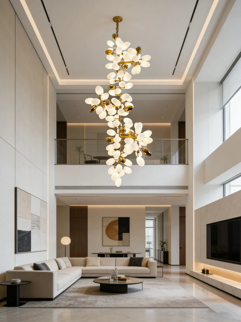 A modern living room with high ceilings featuring a large gold floral cluster chandelier.