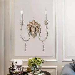 Decorative wall sconce with candles on a wall with molding