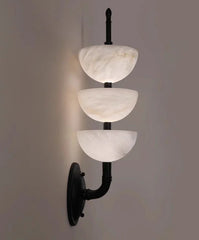 Wall-mounted light fixture with three white glass shades on a gray background