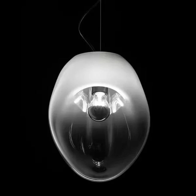 Close-up of a smoke gray glass organic shape pendant light showing the internal bulb socket.