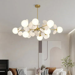 Gold starburst chandelier with multiple white globe lights hanging from a ceiling.