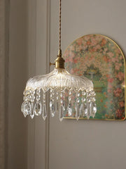 Decorative pendant light with crystal accents on a neutral wall.