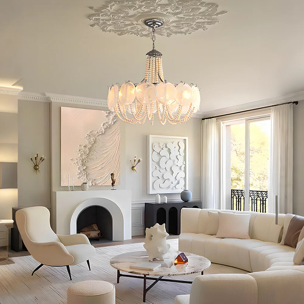 A grand gold chandelier with cascading pearl strings and translucent white glass shades, illuminating a luxurious living room.