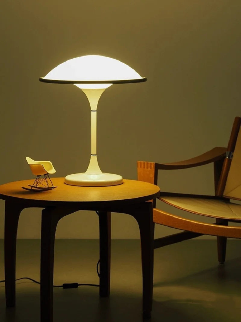 Table lamp on a round wooden table with a chair in the background