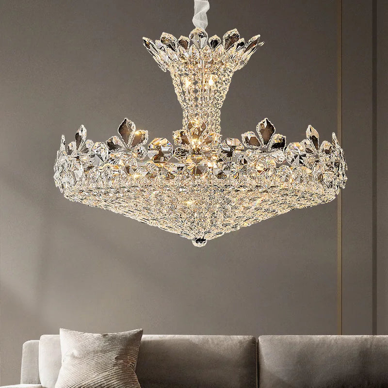 Polished chrome tiered chandelier with cascading crystal and floral accents, illuminated in a living room setting.