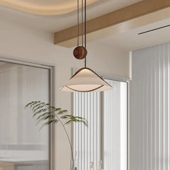 Close-up of the fabric cone pendant light with wood accents, showing the cord and ceiling mount.