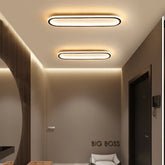 A hallway with two modern oval flush mount ceiling lights installed on the ceiling.