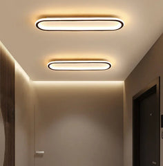 A hallway with two modern oval flush mount ceiling lights installed on the ceiling.