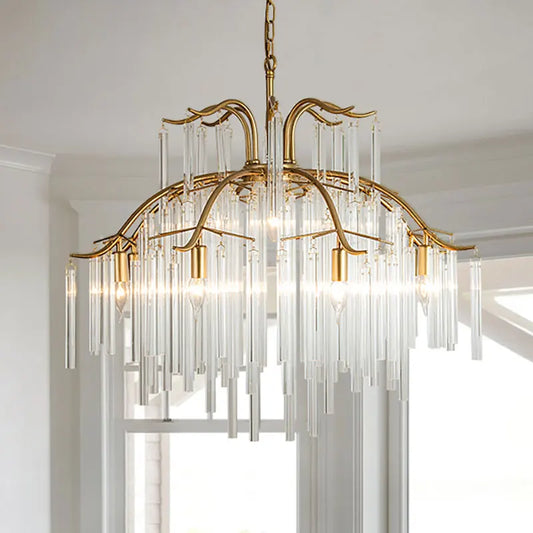 A gold-finished tiered chandelier with numerous clear glass rods cascading downwards, suspended by a chain from a ceiling.