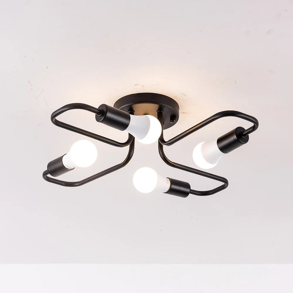 Black metal starburst semi-flush ceiling light fixture with four exposed LED bulbs