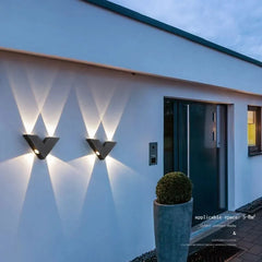 Modern outdoor wall lights on a house exterior with a plant pot.