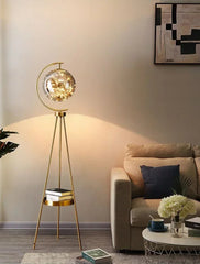 Gold floor lamp in a living room setting with a sofa and coffee table.