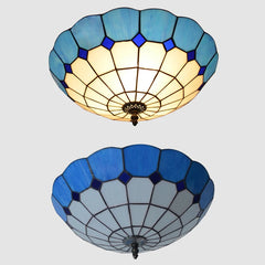 Two blue stained glass ceiling lights with scalloped edges shown from different angles against a neutral background.