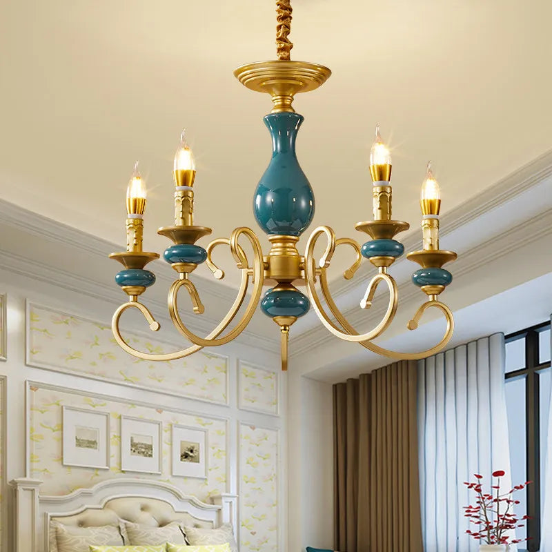 Close-up of the teal ceramic accent on a gold candelabra arm of the chandelier.