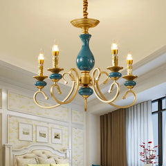 Close-up of the teal ceramic accent on a gold candelabra arm of the chandelier.