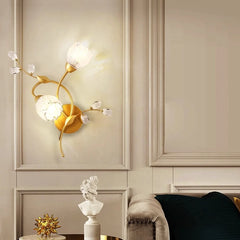 Side view of a gold floral leaf wall sconce, showcasing its curved stem and leaf design.