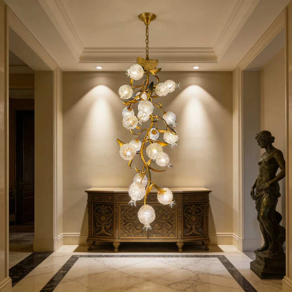Gold floral-shaped chandelier with clear crystal accents hanging above a console table in a hallway.