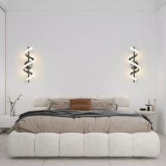 Modern bedroom with a bed, wall lights, and minimal decor.