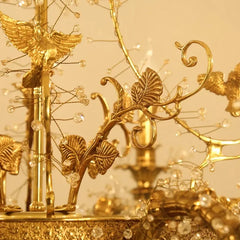 Gold decorative piece with intricate designs and elements on a beige background