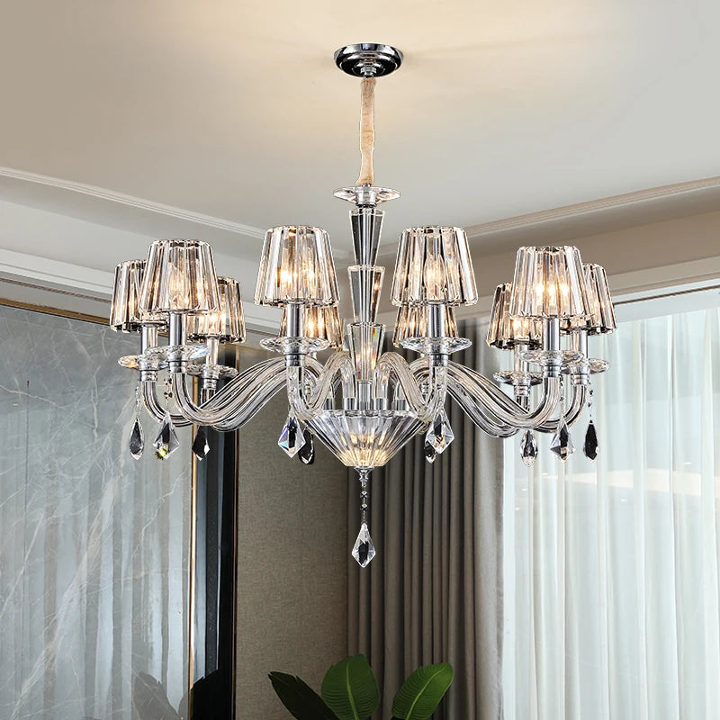 A crystal chandelier with candle-style arms and faceted crystal shades, illuminated and hanging from a ceiling.