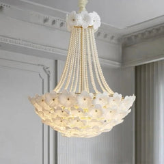 Decorative chandelier with floral design in a room with white walls and ceiling.
