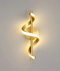 Modern gold wall sconce with a spiral design on a neutral background