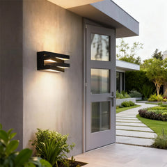 Modern outdoor wall light fixture on a house exterior with a pathway and garden.