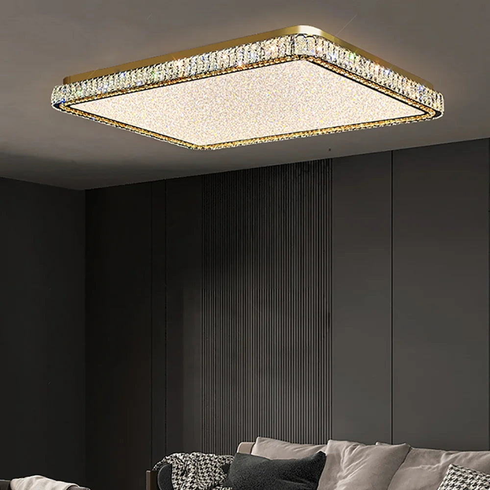 Square gold chandelier with faceted crystals and a frosted white diffuser, installed in a modern living room.