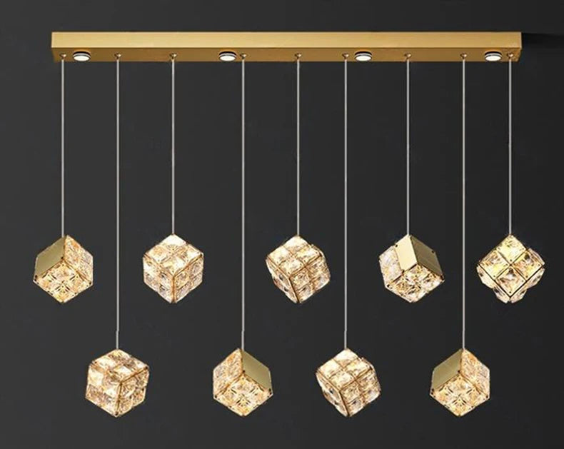Gold pendant light fixture with crystal-like cube lights on a black background