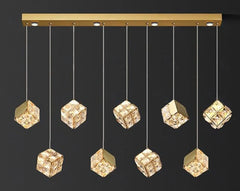 Gold pendant light fixture with crystal-like cube lights on a black background