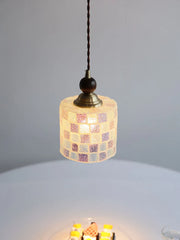 Small pendant light with mosaic glass shade on a gray background