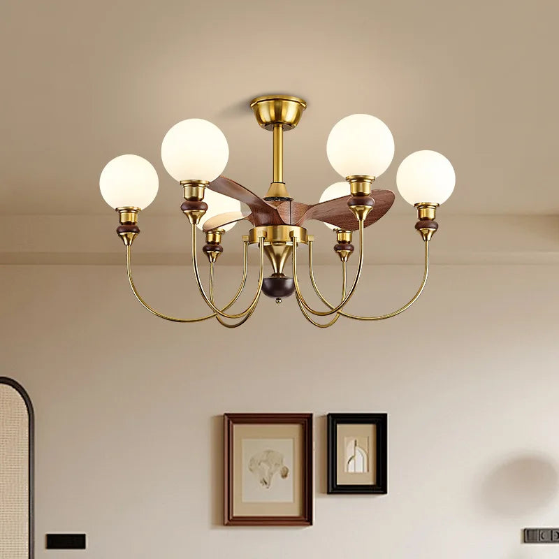 Gold chandelier with white lights in a room with framed pictures on the wall.