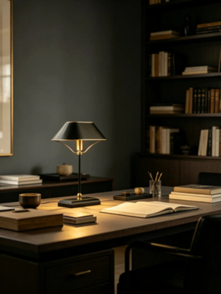 Close-up of the base and stem of a black metal table lamp with polished chrome accents.