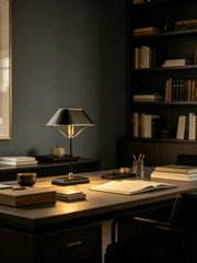 Close-up of the base and stem of a black metal table lamp with polished chrome accents.