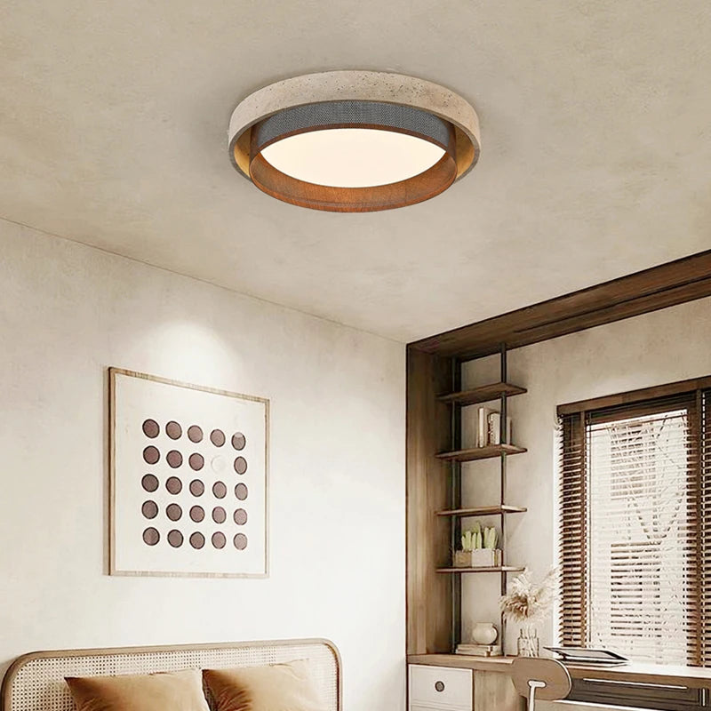 A bedroom interior featuring a stone-textured ring flush mount ceiling light, complementing the decor with its natural aesthetic.