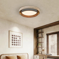 A bedroom interior featuring a stone-textured ring flush mount ceiling light, complementing the decor with its natural aesthetic.