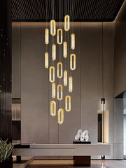 Modern chandelier hanging in a stylish interior setting with a neutral color palette.