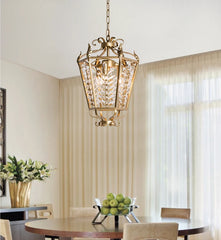 Decorative pendant light hanging above a dining table with green apples and flowers.