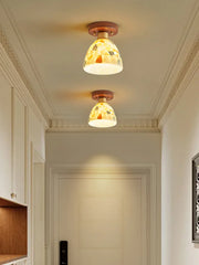 Two ceiling lights with decorative glass shades in a hallway.