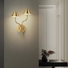 Side view of a brass modern mushroom wall sconce showing its curved arm.