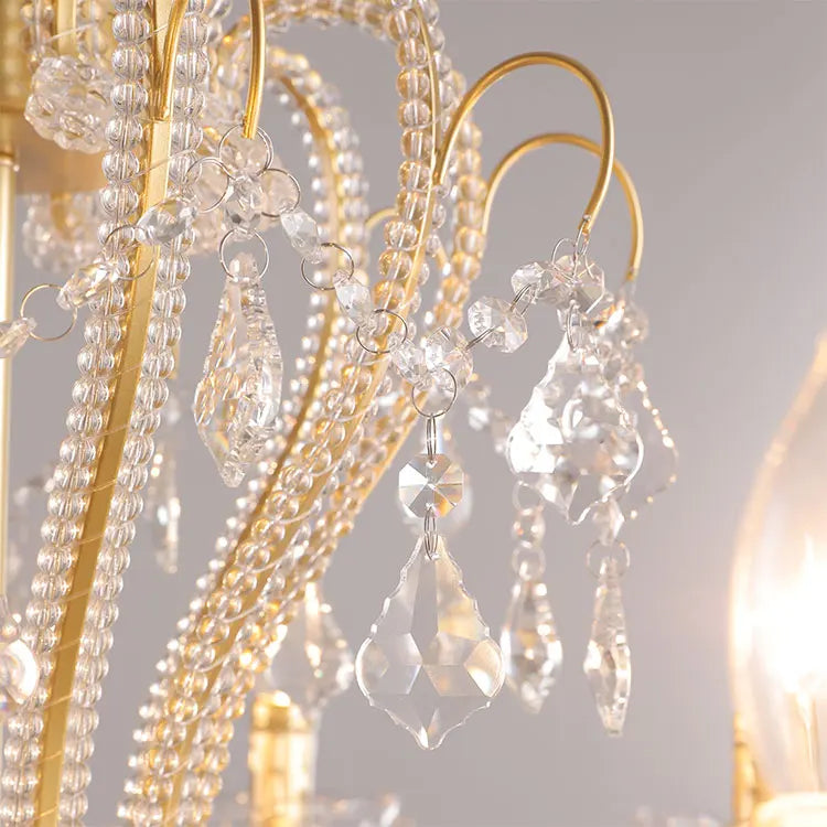 Close-up of a chandelier with crystal beads and gold fixtures.