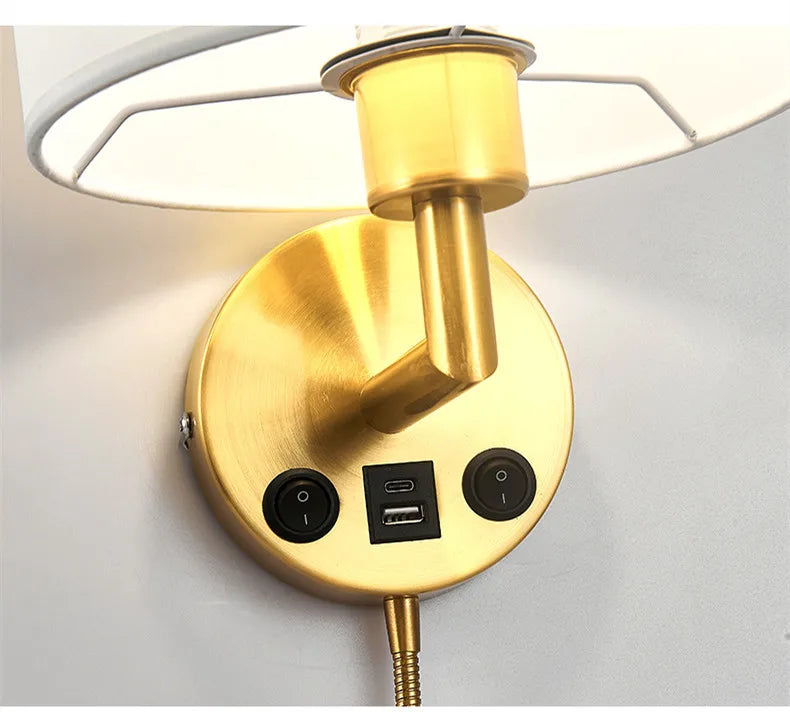Gold wall-mounted lamp with USB port and power switch on a white background