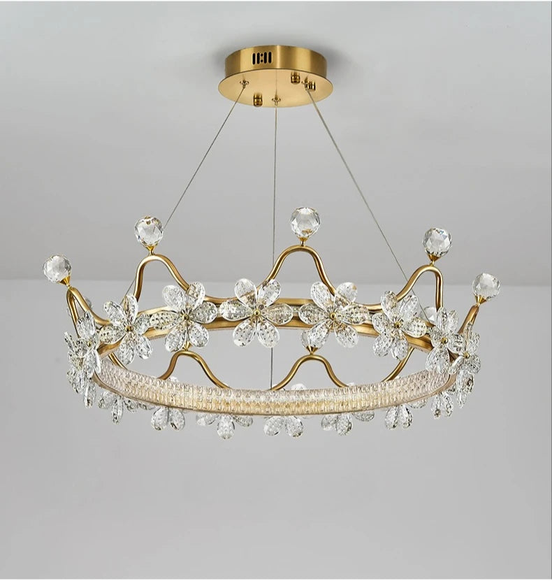 Gold chandelier with crystal accents on a gray background