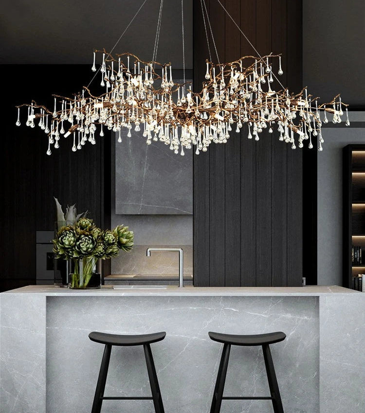 Modern chandelier hanging above a kitchen island with stools.