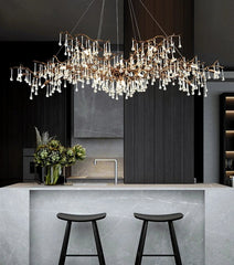 Modern chandelier hanging above a kitchen island with stools.