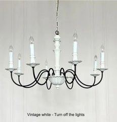 Vintage-style chandelier with white candles on a light gray background