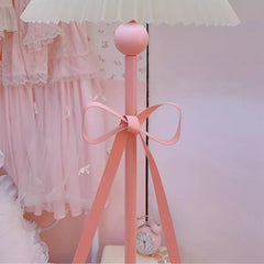 Pink floor lamp with a bow in a room setting